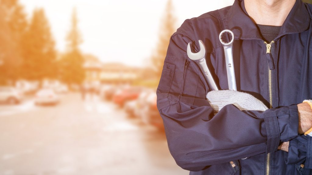 A professional car locksmith holding a set of wrenches